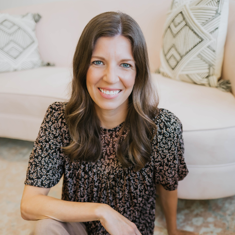 Woman sitting on the floor and smiling at the camera.